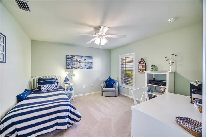 Carpeted bedroom featuring ceiling fan