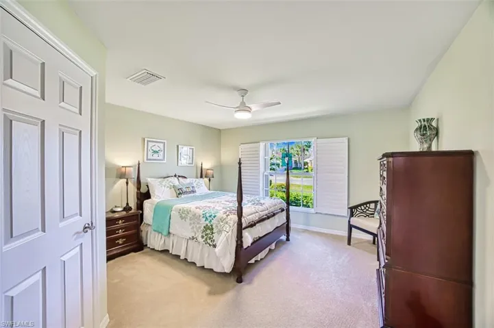 Carpeted bedroom featuring ceiling fan