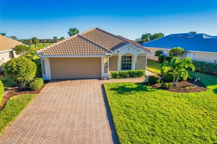Mediterranean / spanish home with a front yard and a garage