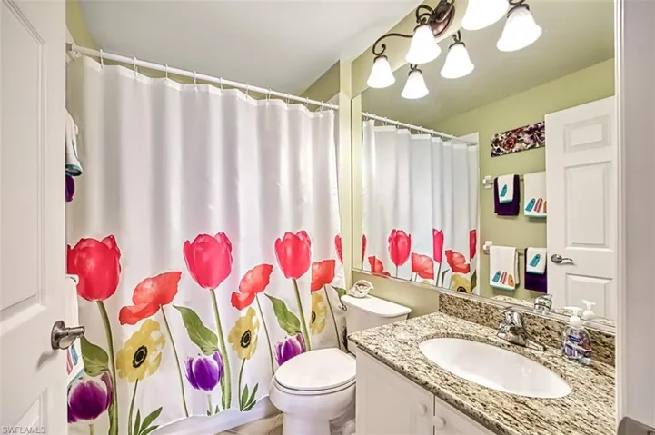 Bathroom with walk in shower, vanity, and toilet