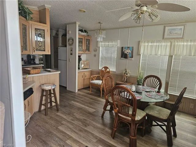 Dining area featuring ceiling fan, dark hardwood / wood-style floors, and a textured ceiling