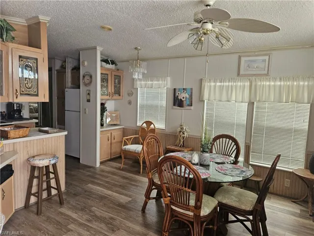 Dining room with a textured ceiling, ceiling fan, and dark hardwood / wood-style flooring