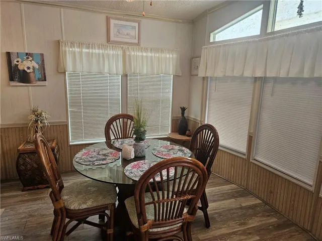 Dining room featuring a textured ceiling, vaulted ceiling, and hardwood / wood-style flooring