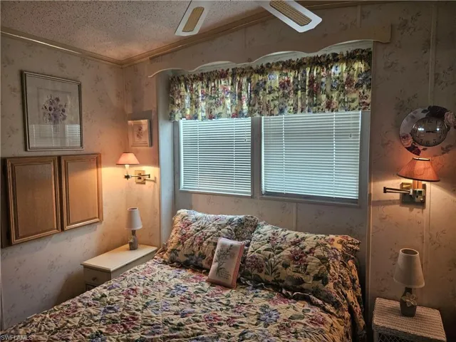 Bedroom featuring a textured ceiling, ceiling fan, and crown molding