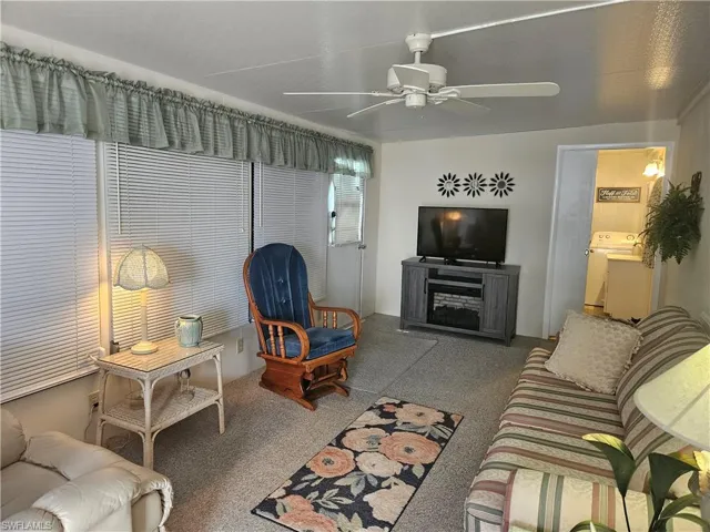 Living room with ceiling fan and washer / dryer