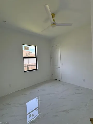 Unfurnished room with ceiling fan and light tile patterned floors