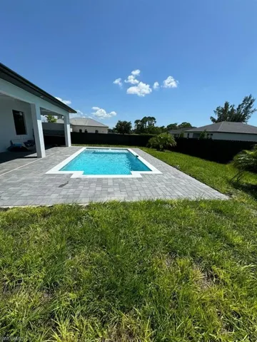 View of swimming pool with a yard and a patio area