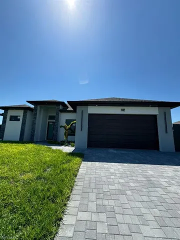 View of front facade featuring a front lawn and a garage