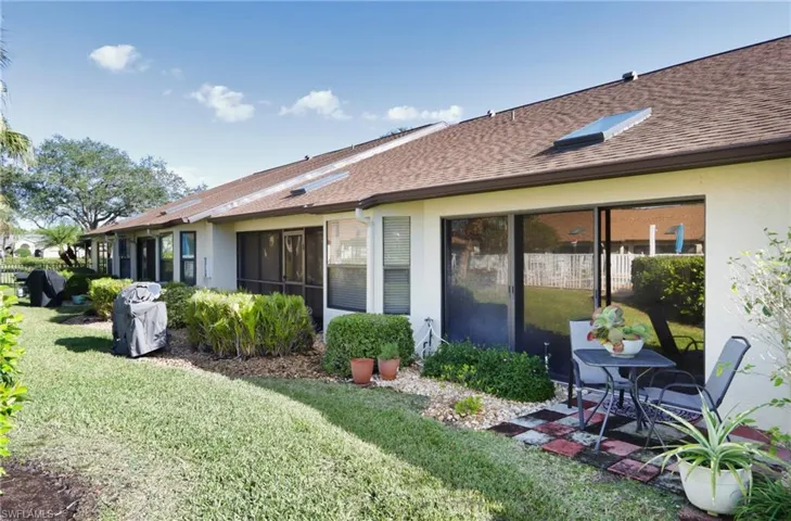 Back of property with a lawn and a patio
