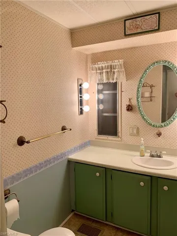 Bathroom featuring vanity, a textured ceiling, tile patterned flooring, and toilet