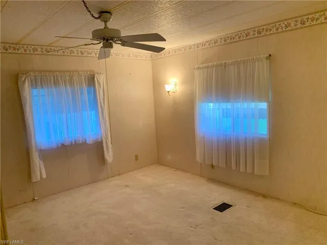Carpeted room featuring ceiling fan
