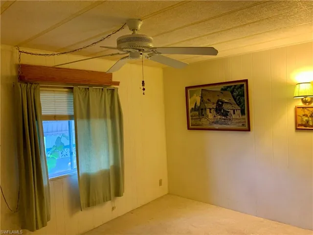 Unfurnished room featuring carpet and ceiling fan
