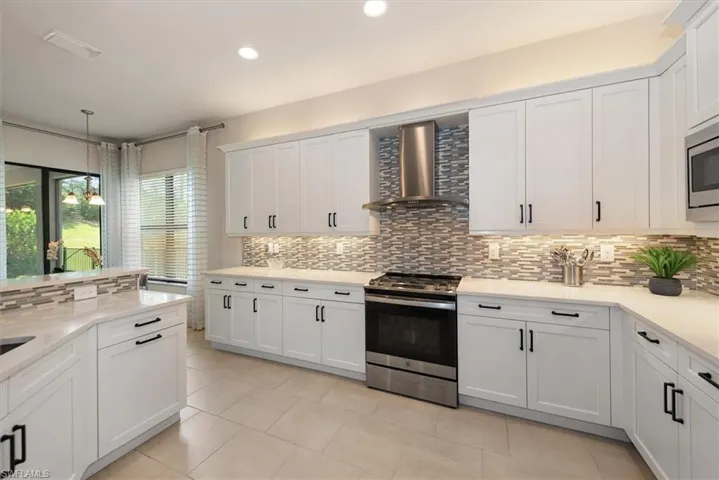 Full bath with two vanities, a bath, and tile patterned floors