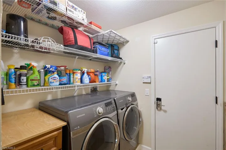 Laundry room featuring independent washer and dryer and a textured ceiling