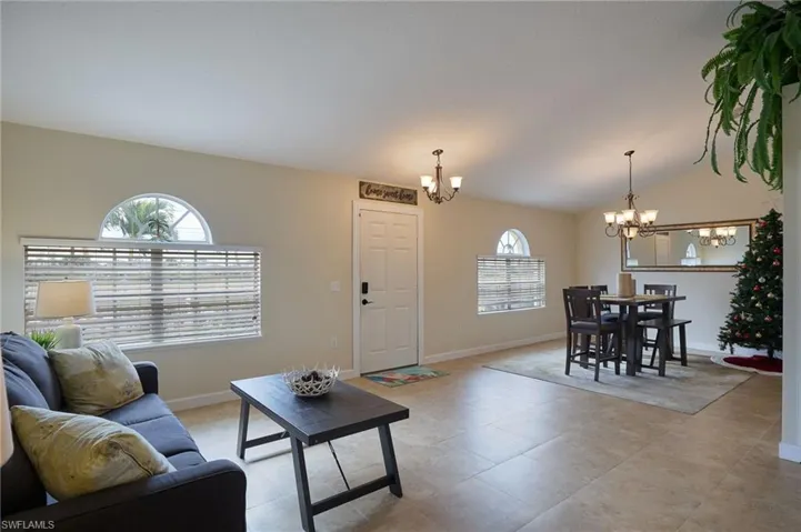 Living room with a notable chandelier and lofted ceiling