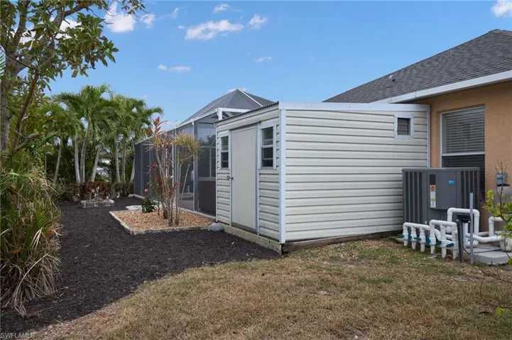 View of side of home with a lawn and cooling unit