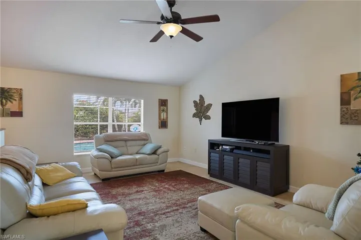 Living room featuring ceiling fan and lofted ceiling