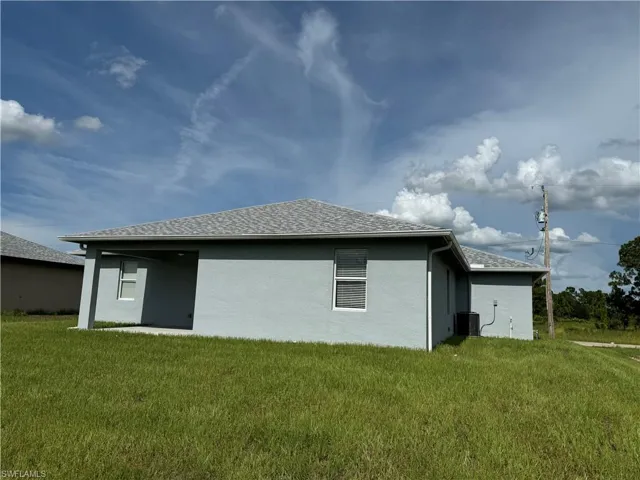 View of home's exterior featuring central air condition unit and a lawn