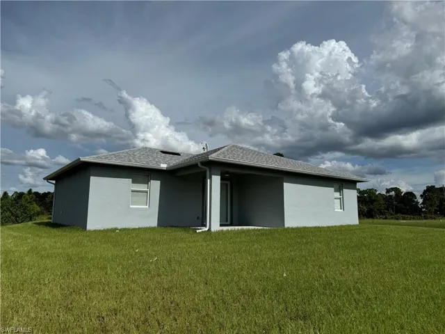 Rear view of house featuring a yard