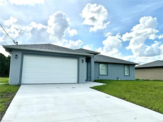 Single story home with a garage and a front yard