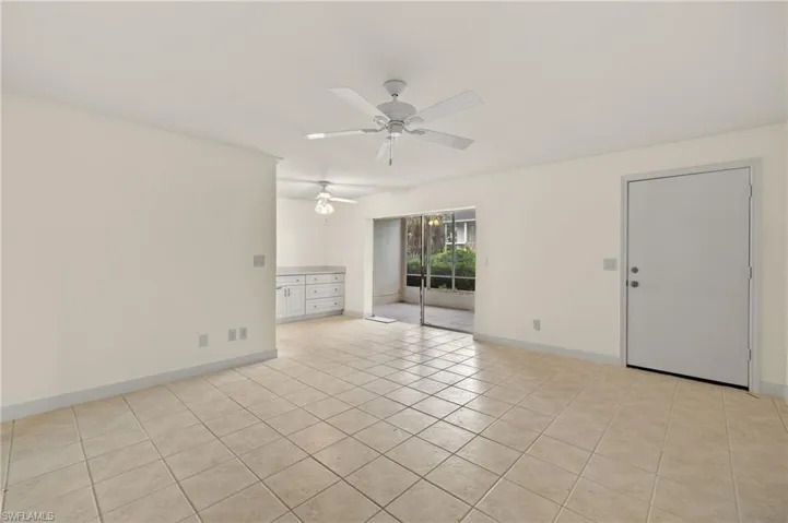 Empty room featuring ceiling fan and light tile patterned floors