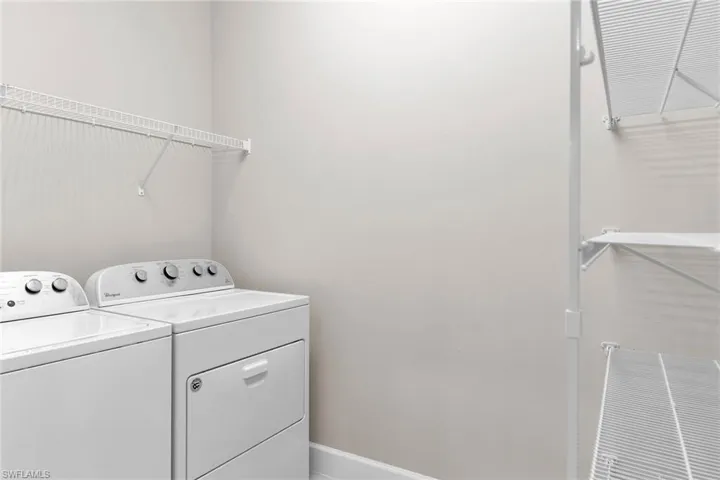 Washroom featuring independent washer and dryer and baseboards