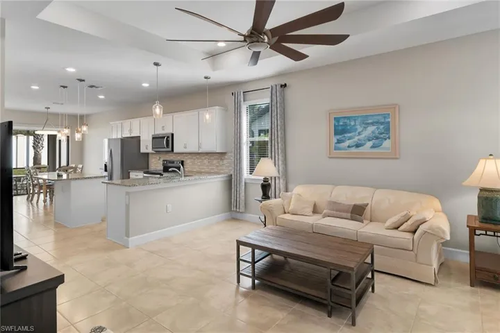 Living room featuring light tile patterned floors, a ceiling fan, and recessed lighting