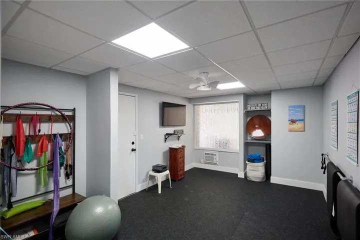 Workout area featuring a paneled ceiling and ceiling fan