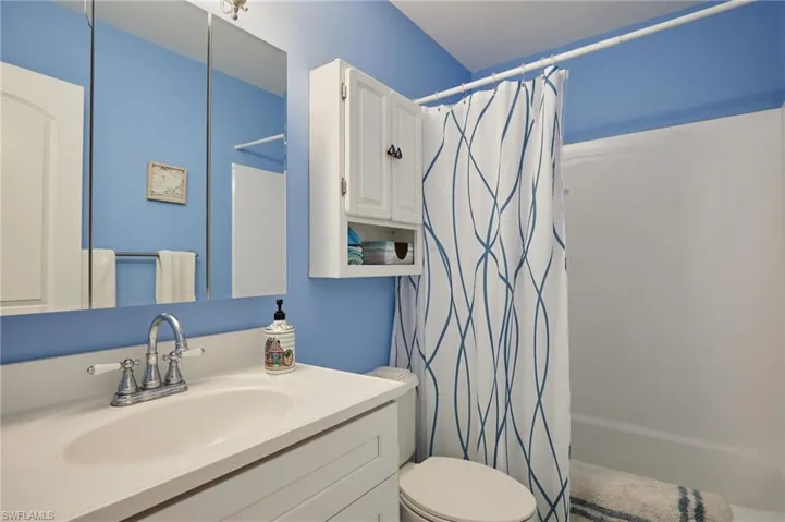 Bathroom featuring vanity and shower / bath combination with curtain