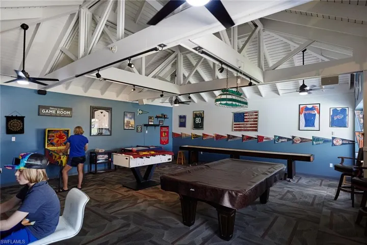 Recreation room featuring ceiling fan, billiards, beamed ceiling, and high vaulted ceiling