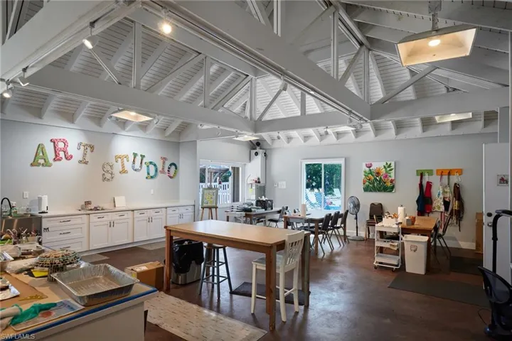 Dining area featuring finished concrete flooring, high vaulted ceiling, beamed ceiling, and rail lighting