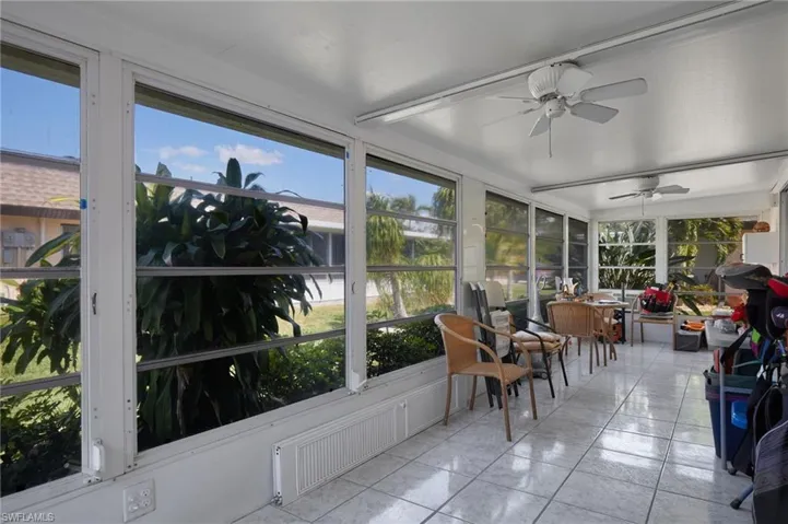 Sunroom featuring ceiling fan, outdoor dining area, and tile patterned flooring