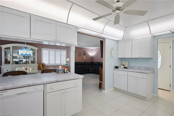 Kitchen with white dishwasher and white cabinets