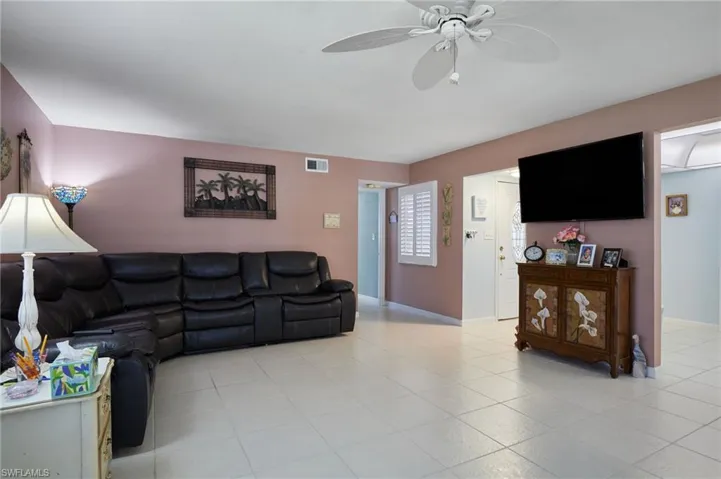 Living area with a ceiling fan and light tile patterned floors