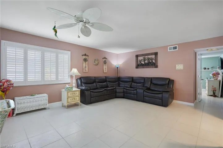 Living area featuring tile patterned flooring and ceiling fan