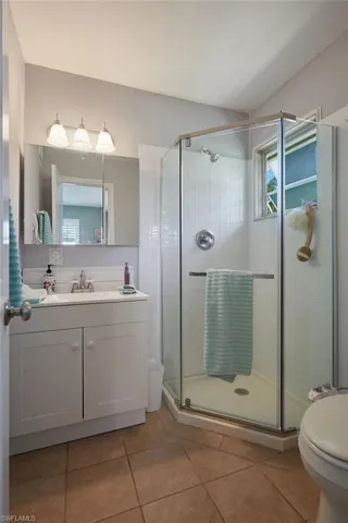 Full bathroom featuring vanity, a shower stall, and light tile patterned floors