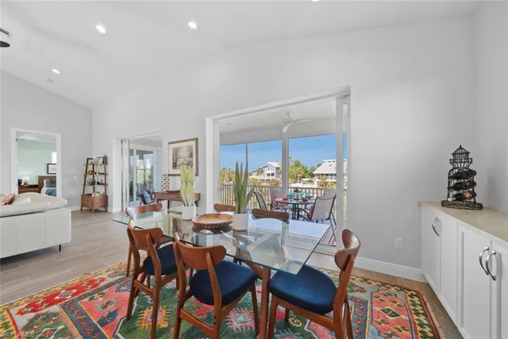 Dining space with light hardwood / wood-style floors, vaulted ceiling, and ceiling fan