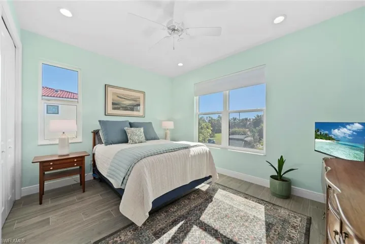 Bedroom with wood-type flooring, a closet, and ceiling fan