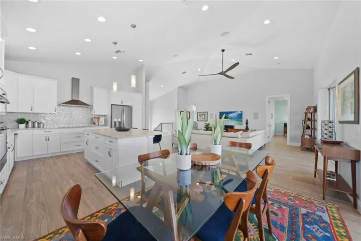 Dining area featuring ceiling fan, high vaulted ceiling, and light wood-type flooring