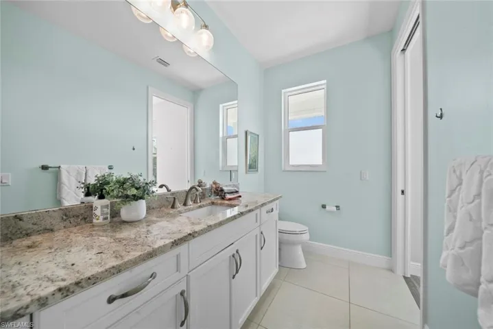 Bathroom with tile patterned flooring, vanity, and toilet