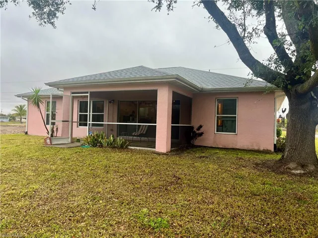 Rear view of house featuring a yard and a sunroom