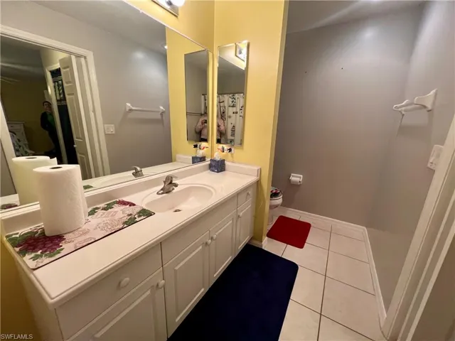 Primary bathroom with toilet, vanity, and tile patterned floors