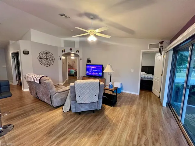 Living room featuring cathedral ceilings, ceiling fan, and light hardwood / wood-style flooring