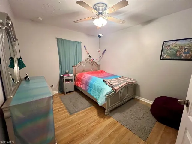 Bedroom with ceiling fan and light wood-type flooring