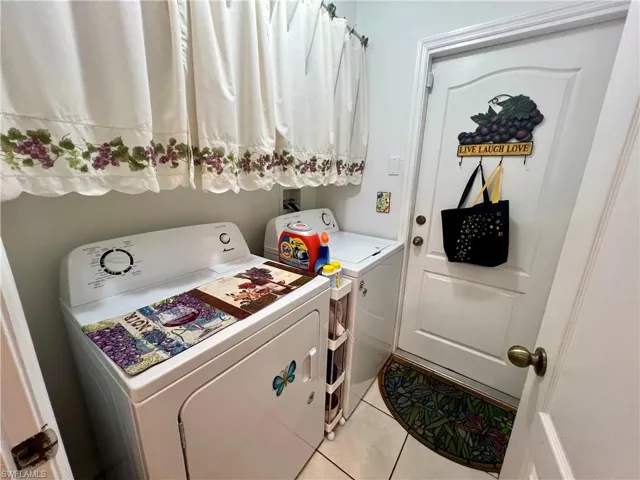 Laundry room with light tile patterned floors and separate washer and dryer