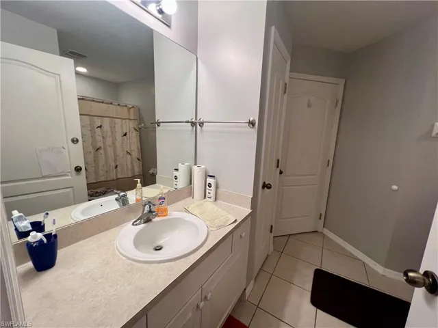Bathroom featuring vanity, tile patterned floors, and a shower with shower curtain