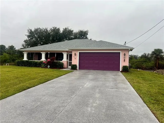 View of front of house with a front yard and a garage and an extra long driveway for plenty of cars.