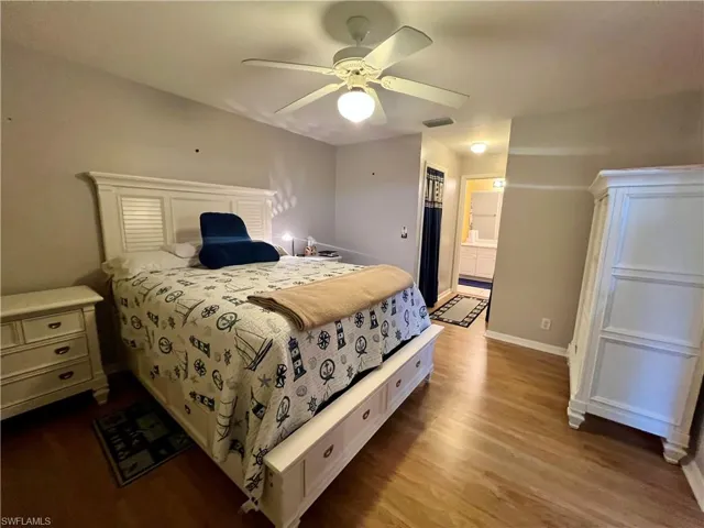 Primary bedroom with ceiling fan, light wood-type flooring, and connected bathroom