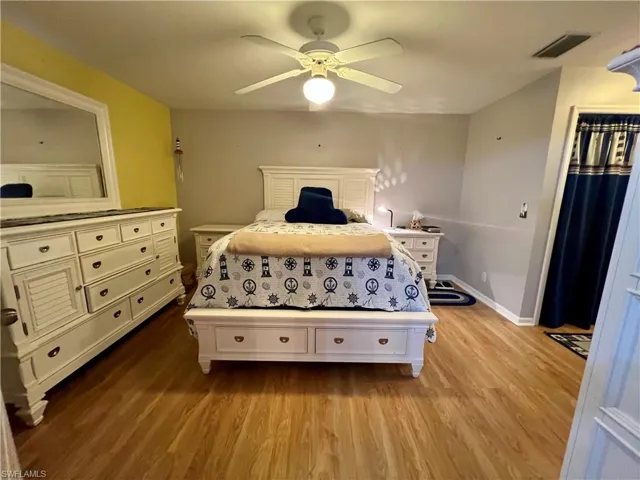 Primary bedroom featuring ceiling fan and light hardwood / wood-style flooring