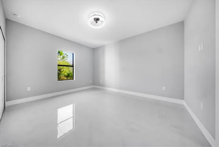 Empty room with finished concrete floors and baseboards